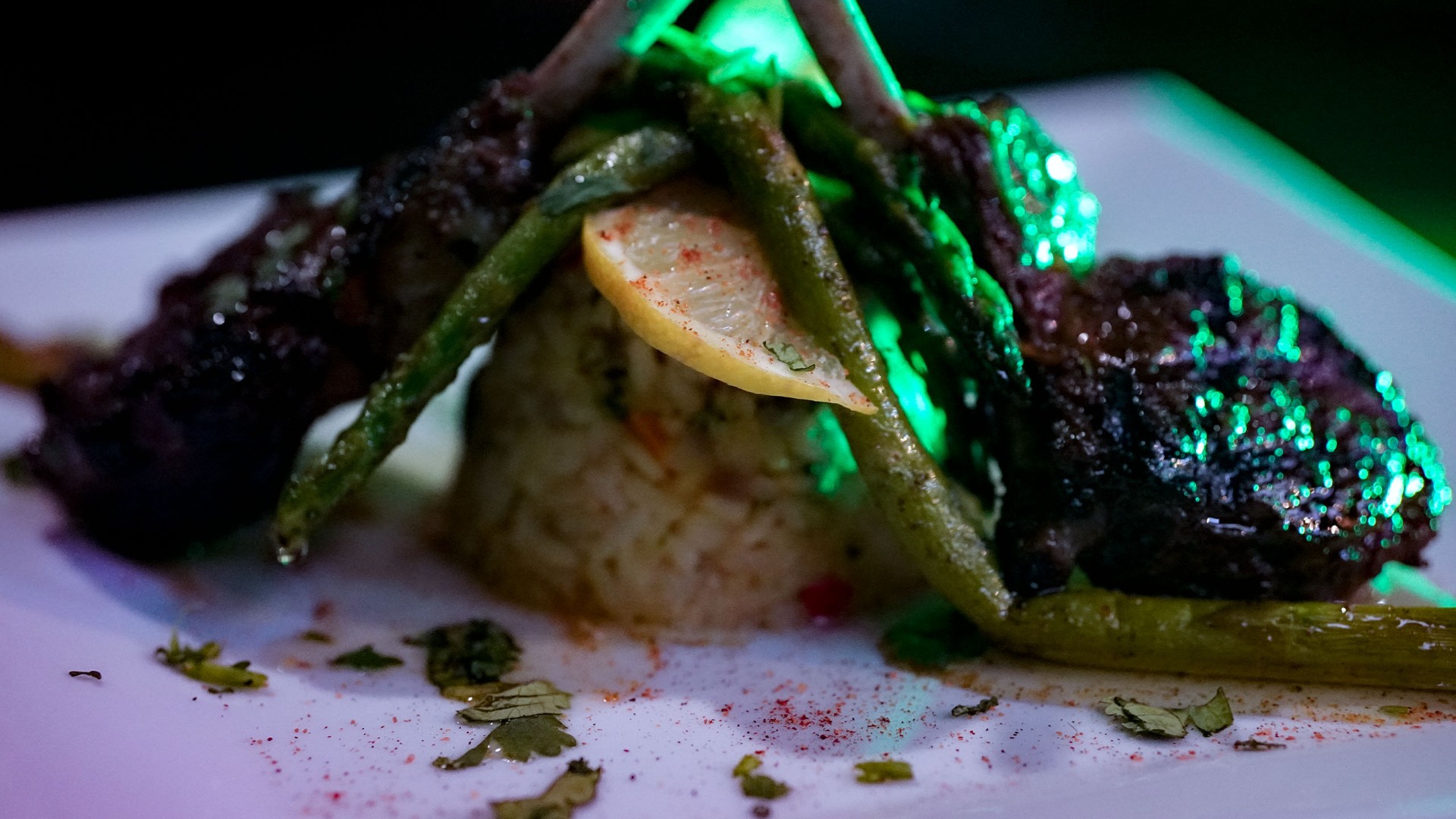 Paragon lamb chops with jasmine rice and asparagus under emerald lounge lighting